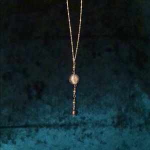 Handmade glass bead on handmade necklace.